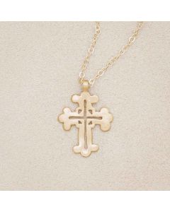 14k yellow gold work of art cross necklace, on beige background
