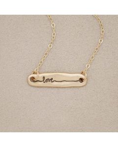 14k yellow gold written with love necklace, on beige background