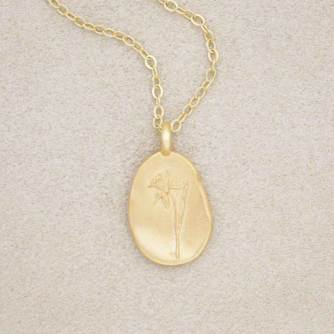gold plated December birth flower necklace with an 18" gold filled link chain, on beige background