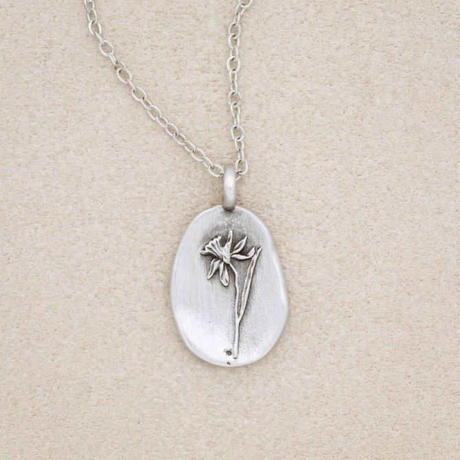 a pewter December birth flower necklace with an 18" link chain, on a beige background