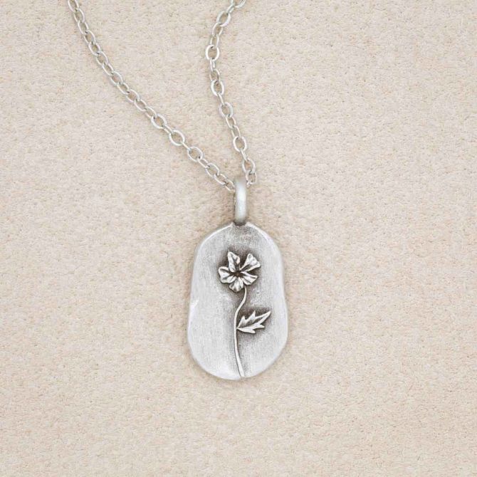 pewter February Birth Flower necklace with an 18" link chain, on a beige background