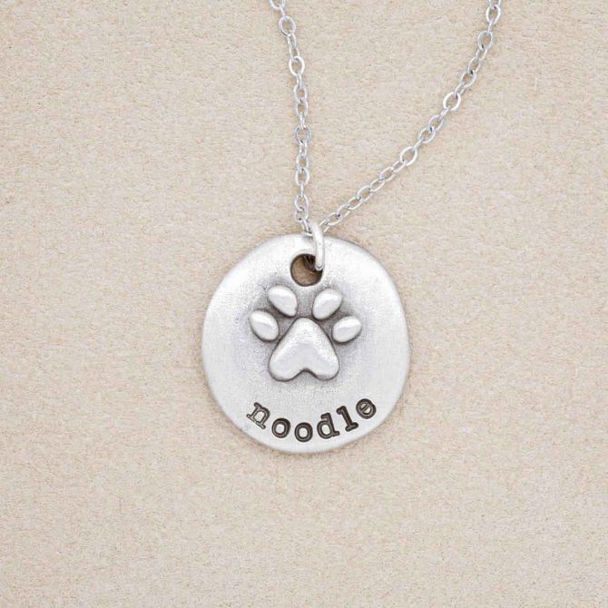 Furry footprint necklace handcrafted in pewter with a paw engraved and personalized with a pet's name