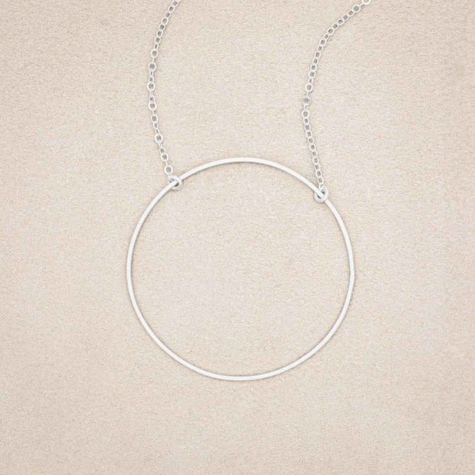 A sterling silver It All Matters Circle Necklace, on beige background
