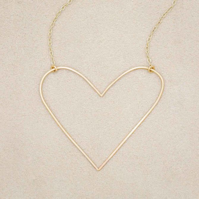 A gold filled Large Peaceful Heart Necklace, on beige background