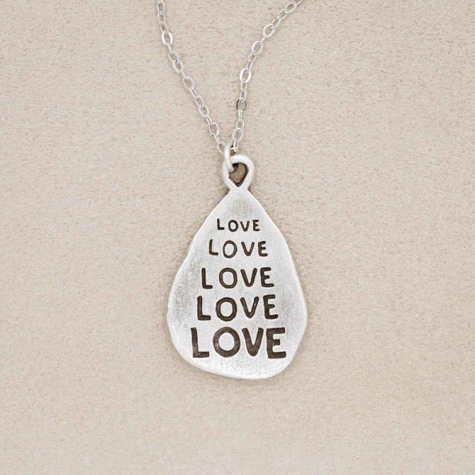 Our Love Grows Necklace, cast in pewter, on a suede background