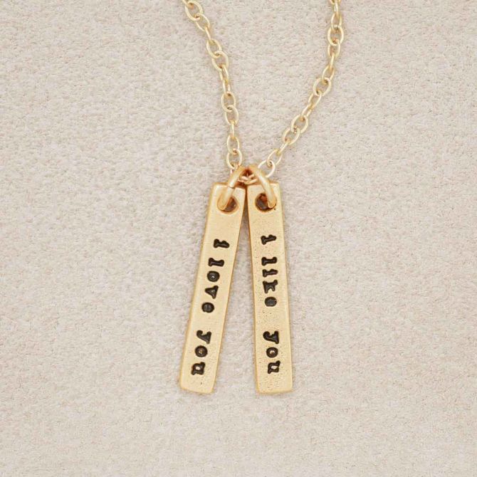 A gold plated The Story of Us Necklace that includes one "i like you" and one "i love you" tag