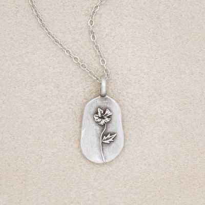 pewter February Birth Flower necklace with an 18" link chain, on a beige background