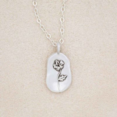 sterling silver February birth flower necklace, on beige background