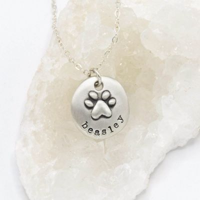Furry footprint necklace handcrafted in sterling silver with a paw engraved and personalized with a pet's name
