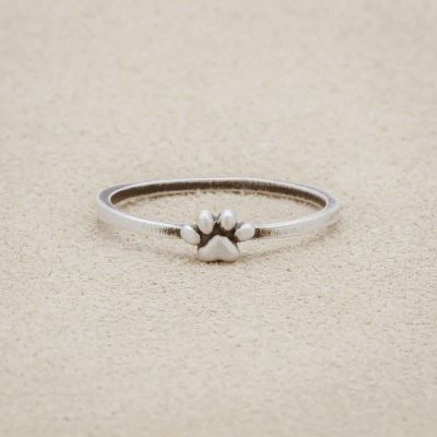 Furry Footprint Dainty Ring handcrafted in sterling silver, on a suede background