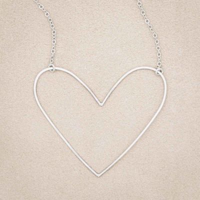A sterling silver Large Peaceful Heart Necklace, on beige background