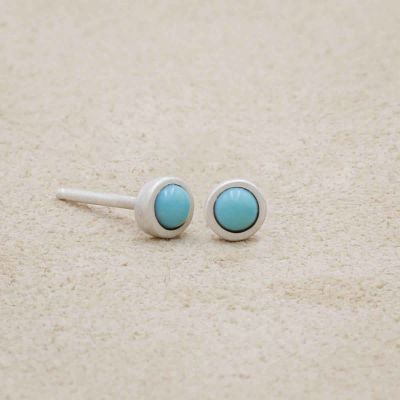 sterling silver Lighthearted Turquoise Stud Earrings on beige background