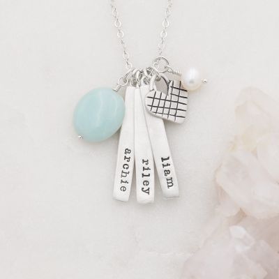 Cross my heart necklace handcrafted in sterling silver with silver tags personalized with a special name hung next to a vintage freshwater pearl and an aqua stone