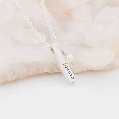 sterling silver word of the year necklace laying on marble
