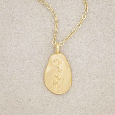 gold plated May birth flower necklace with an 18" gold filled link chain, on beige background