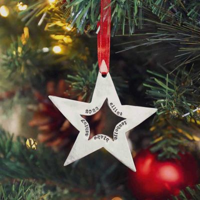 Molded star ornament hand-molded and cast in fine pewter hung from a sheer red ribbon and personalized with a up to five words placed on Christmas tree