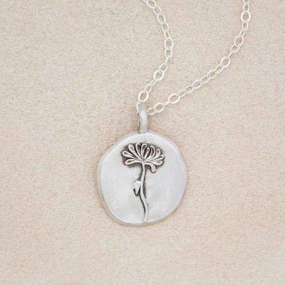 a sterling silver November birth flower necklace on beige background