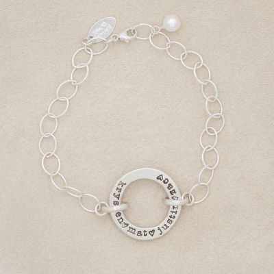 Sterling silver open circle pearl bracelet with a dangling freshwater pearl on suede background