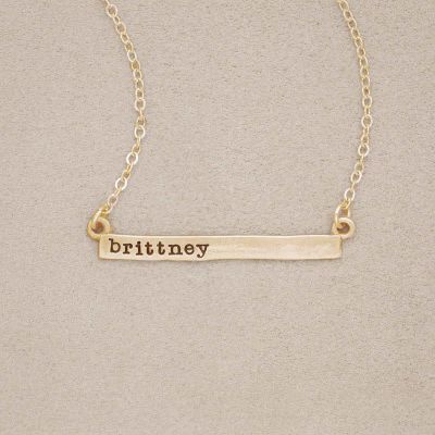 14k yellow gold personalized cross bar necklace customized with name or phrase, on beige background