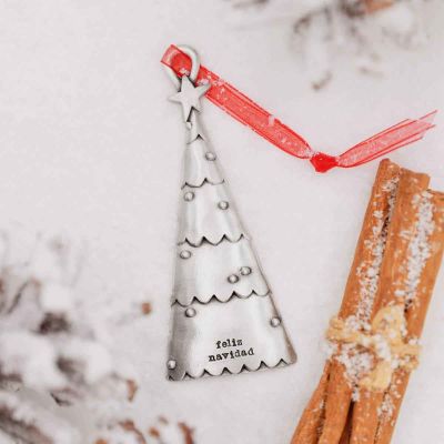 a pewter Scalloped Christmas Tree Ornament on fake snow, personalized with a meaningful phrase and names