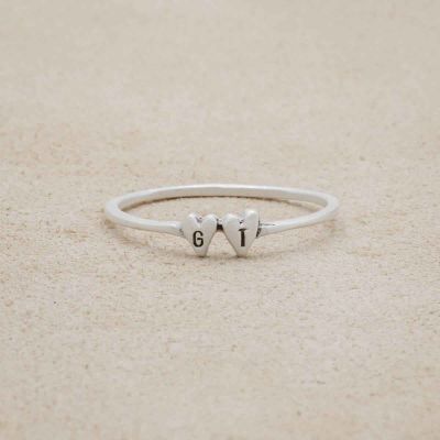 sterling silver Sweet Love Initial Ring - Two Hearts, on a beige background