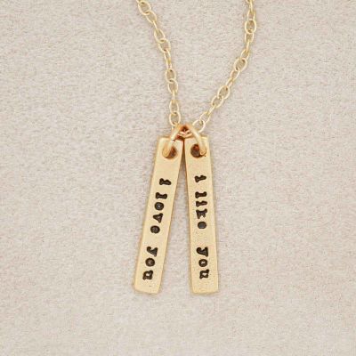A gold plated The Story of Us Necklace that includes one "i like you" and one "i love you" tag