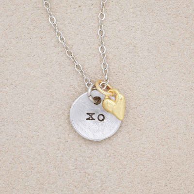 this is love necklace handcrafted in pewter with small gold plated heart charm, on beige background