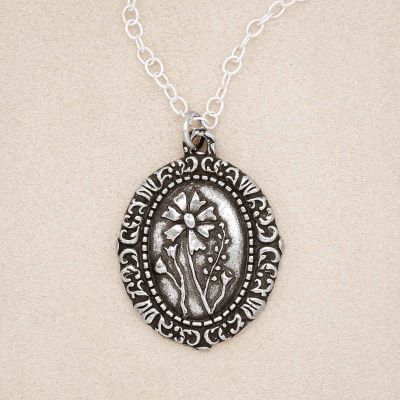 Pewter vintage cameo necklace on suede background