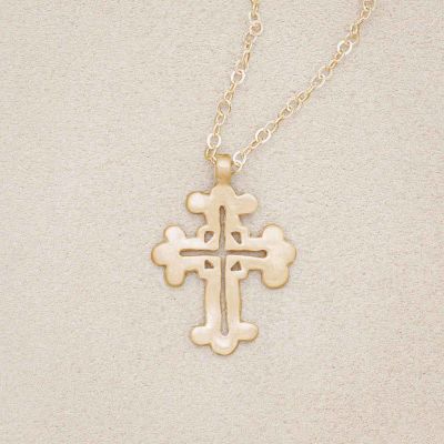14k yellow gold work of art cross necklace, on beige background
