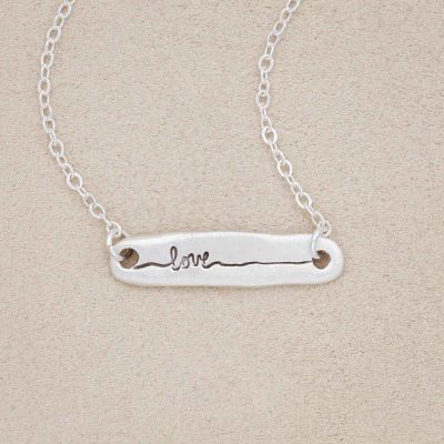 sterling silver written with love necklace, on a beige background