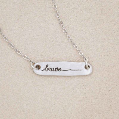 you are brave pewter necklace, on a beige background