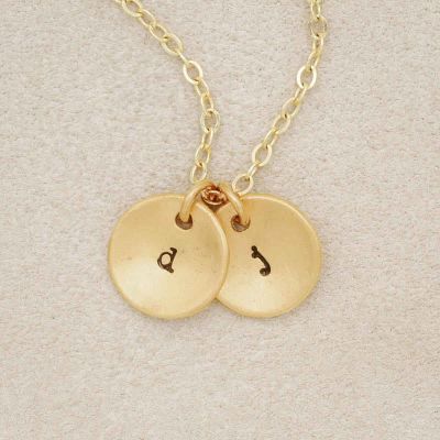 You Are Golden Initial Necklace, personalized with gold plated initial charms, on a beige background